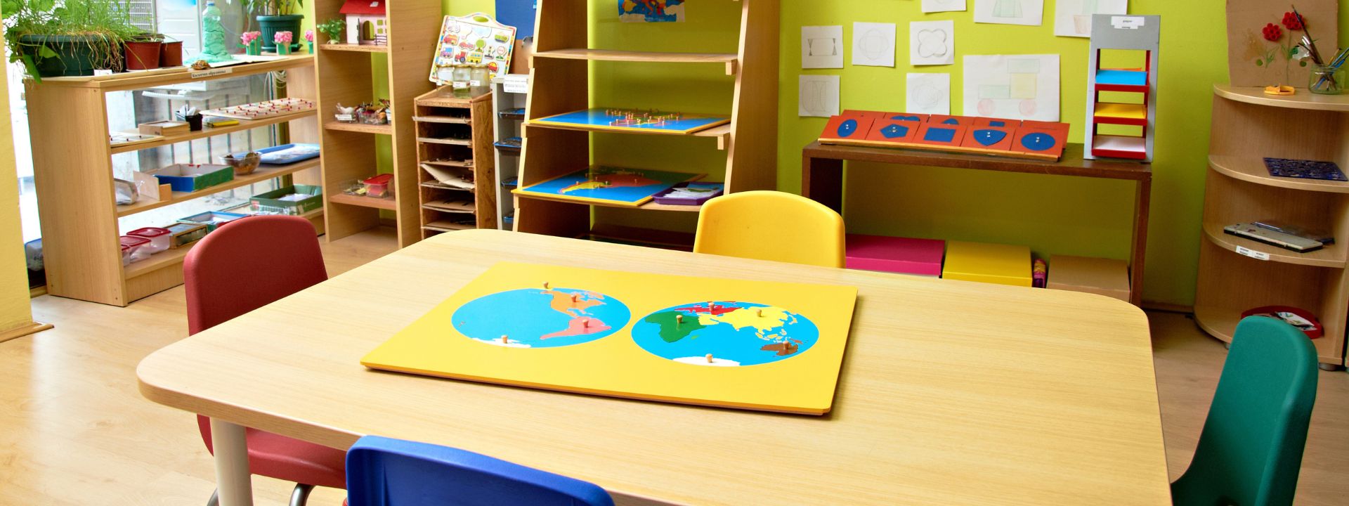 Colorful preschool classroom with educational materials and artwork on the walls