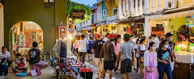 Crowded evening street market with shops and pedestrians in Phuket Old Town