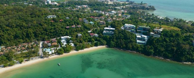 Aerial view of a secluded Phuket bay with hillside villas and low-density coastal development