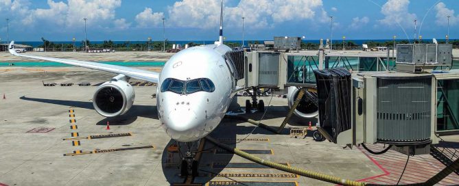 Passenger aircraft parked at Phuket International Airport gate with jet bridge connected