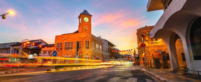 Phuket Old Town clock tower and Sino-Portuguese buildings at dusk with traffic light trails