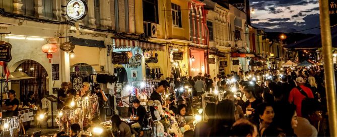 Crowded night market along Phuket Old Town street with shops, street vendors, and evening crowds