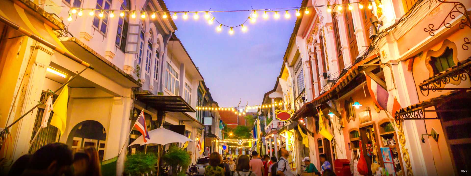 Evening street scene in Thalang Town, Phuket, showing historic shophouses and local community life