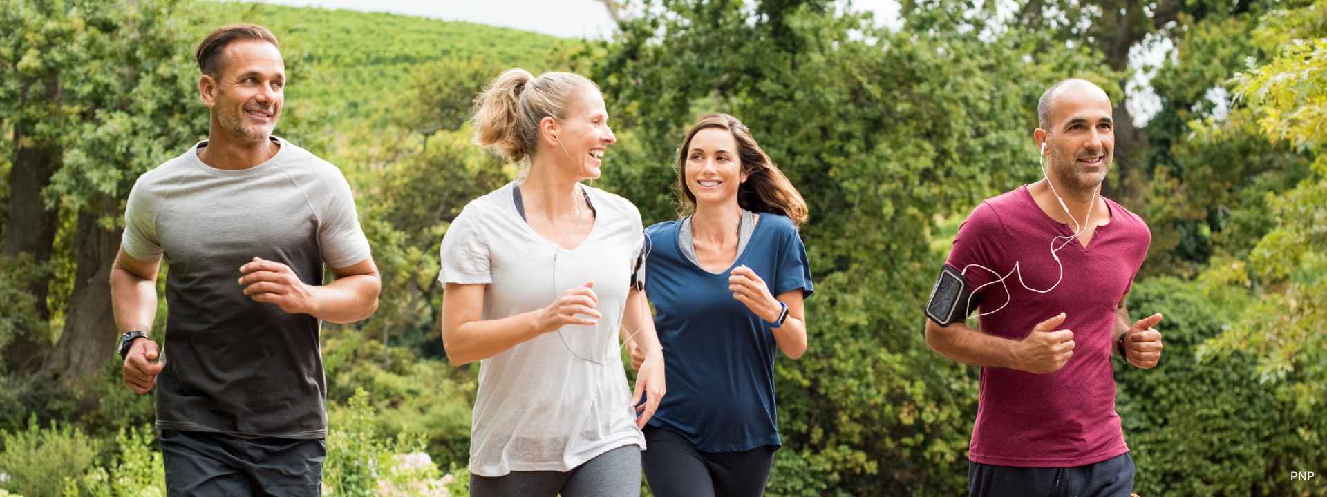 Group of adults jogging outdoors in a green park environment in Phuket