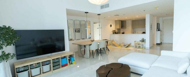 Modern open-plan condominium interior in Phuket with living area, dining table, and contemporary kitchen