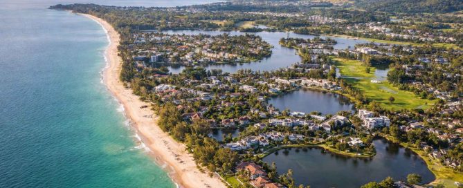 Aerial view of Bang Tao Beach, Laguna and Cherng Talay in Phuket showing luxury residential developments and coastline
