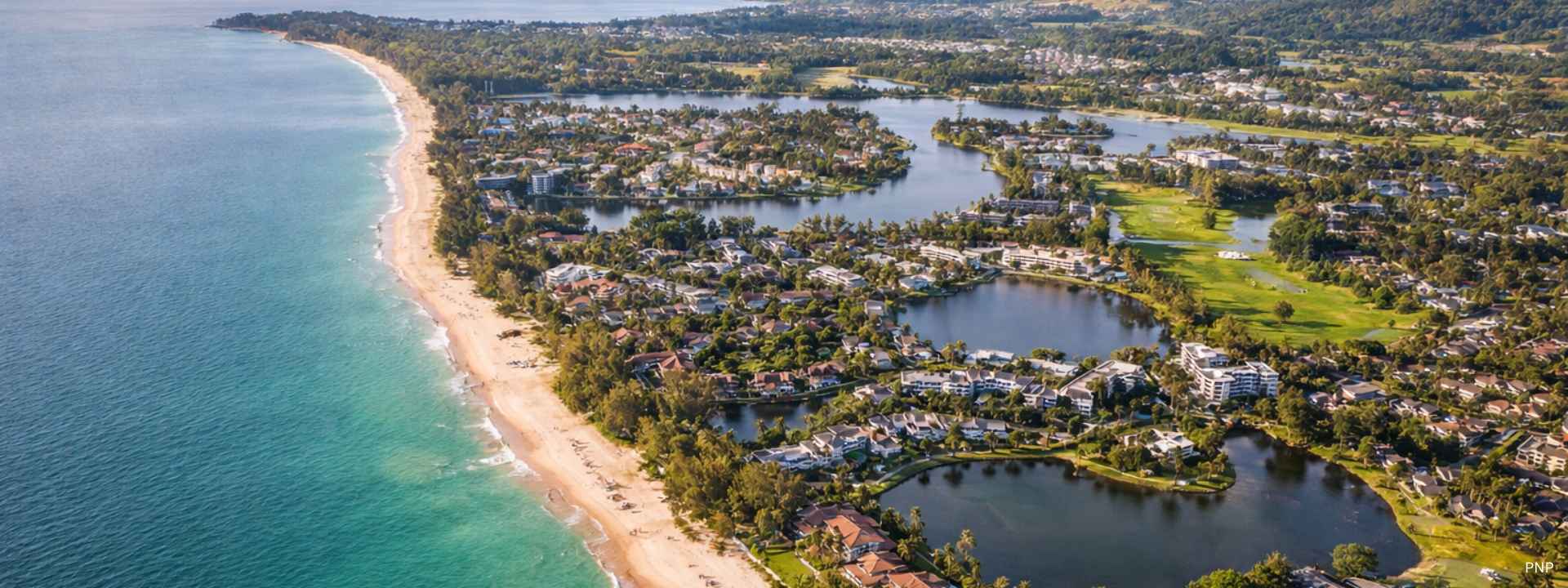 Aerial view of Bang Tao Beach, Laguna and Cherng Talay in Phuket showing luxury residential developments and coastline