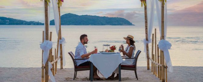 Foreign couple enjoying dinner on a beach in Phuket representing the lifestyle attracting long-stay visa applicants