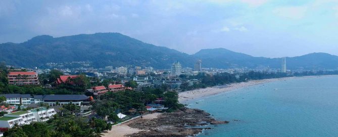 Patong Beach coastline in Phuket showing dense coastal development between mountains and the sea