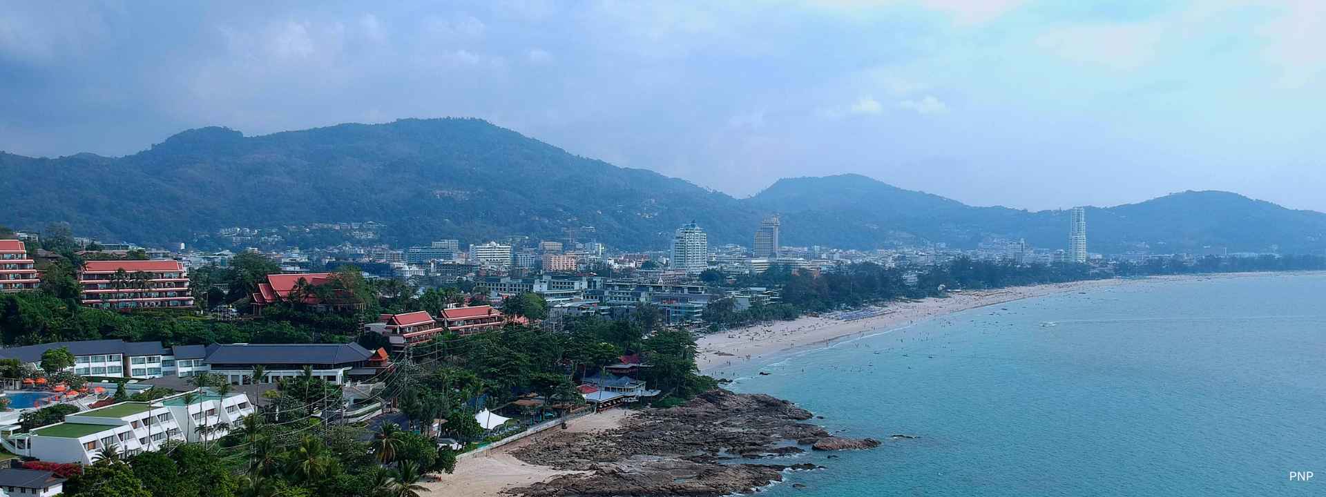 Patong Beach coastline in Phuket showing dense coastal development between mountains and the sea