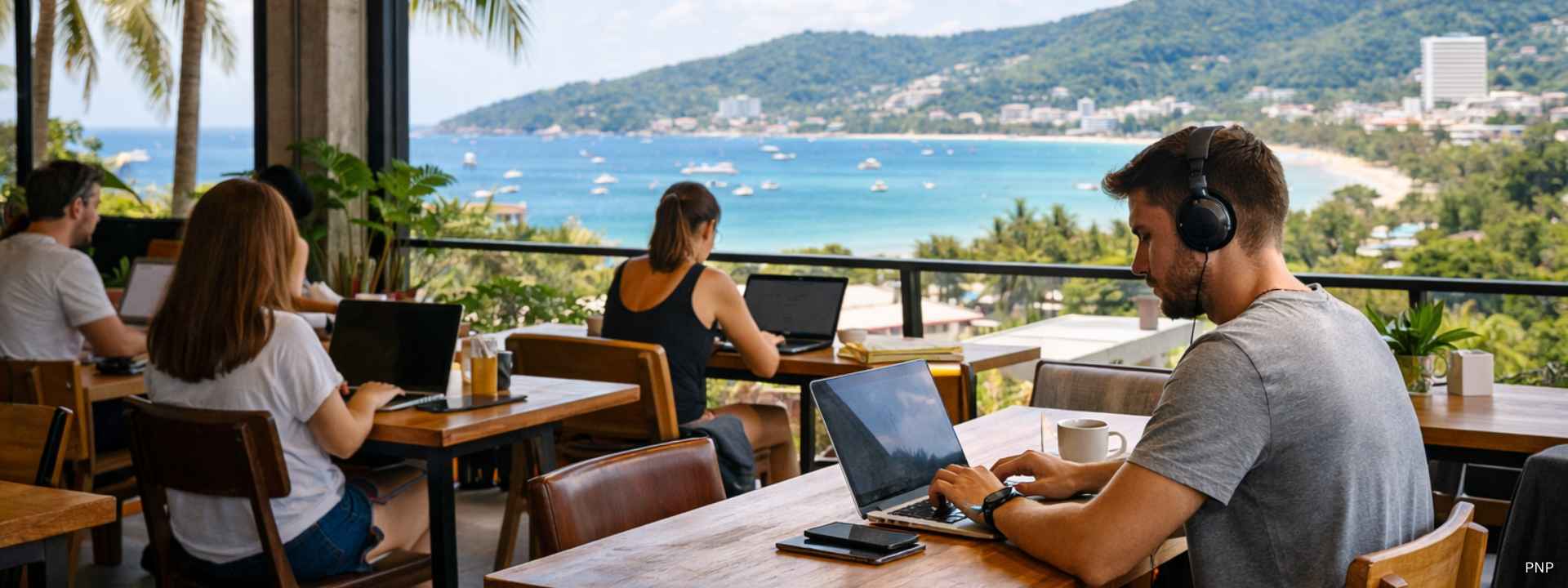 People working on laptops in a modern Phuket coworking space with a sea view, reflecting the growth of remote work